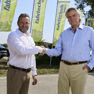 Bild von einem Handschlag von Andreas Rouschal (links im Bild) mit Vorgänger Karl-Martin Studener (rechts im Bild) für gelben ÖAMTC-Fahrtechnik-Fahnen
