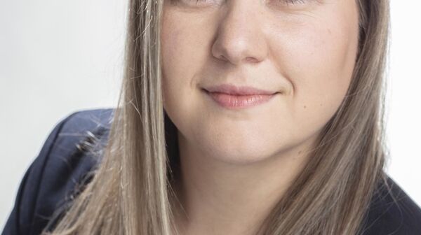 Das Bild ist ein Portraitfoto von Reiseexpertin Redel Dagmar. Sie hat lange dunkelblonde Haare, trägt eine weiße Bluse und einen schwarzen Blazer.