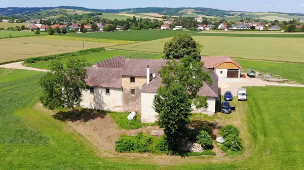 Gebäude der Mühle in Breitenwaida bei Hollabrunn, die Urlaubs-, Therapie- und Beratungszentrum sind, eingebettet in grüner, hügeliger Landschaft.