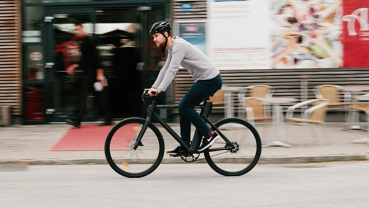 Radfahrer mit Helm fährt auf einem Urban E-Bike.