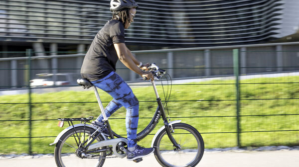 Eine junge Frau übt auf einem Mini-Fahrrad das Radfahren.
