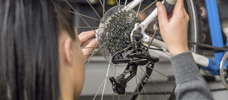 ÖAMTC Technikerin überprüft die Gangschaltung am Hinterrad