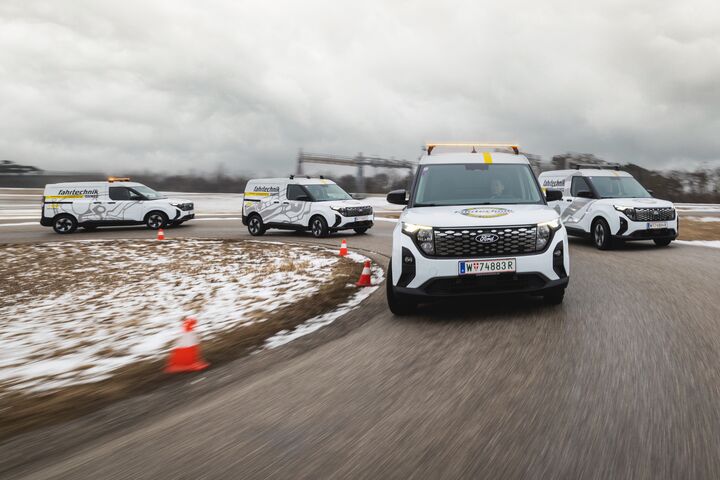 Auf einer Handlingstrecke ist ein Fahrzeugkonvoi von vier Ford E-Transits zu sehen, die für die Geländetechniker der ÖAMTC Fahrtechnik angeschafft worden sind