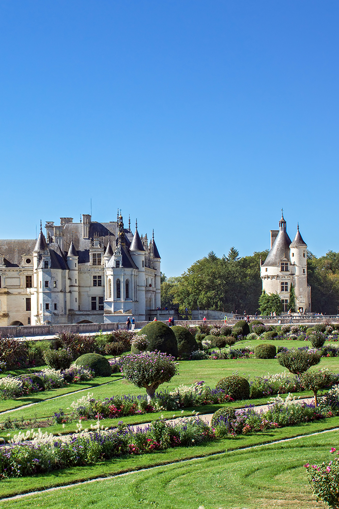 Blick auf das Château de Chenonceau (Frankreich) mit seinen Bögen über dem Fluss Cher und den gepflegten Gärten