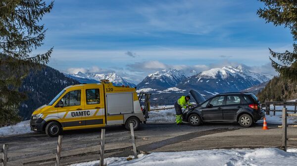 Pannenfahrer vor geöffneter Motorhaube