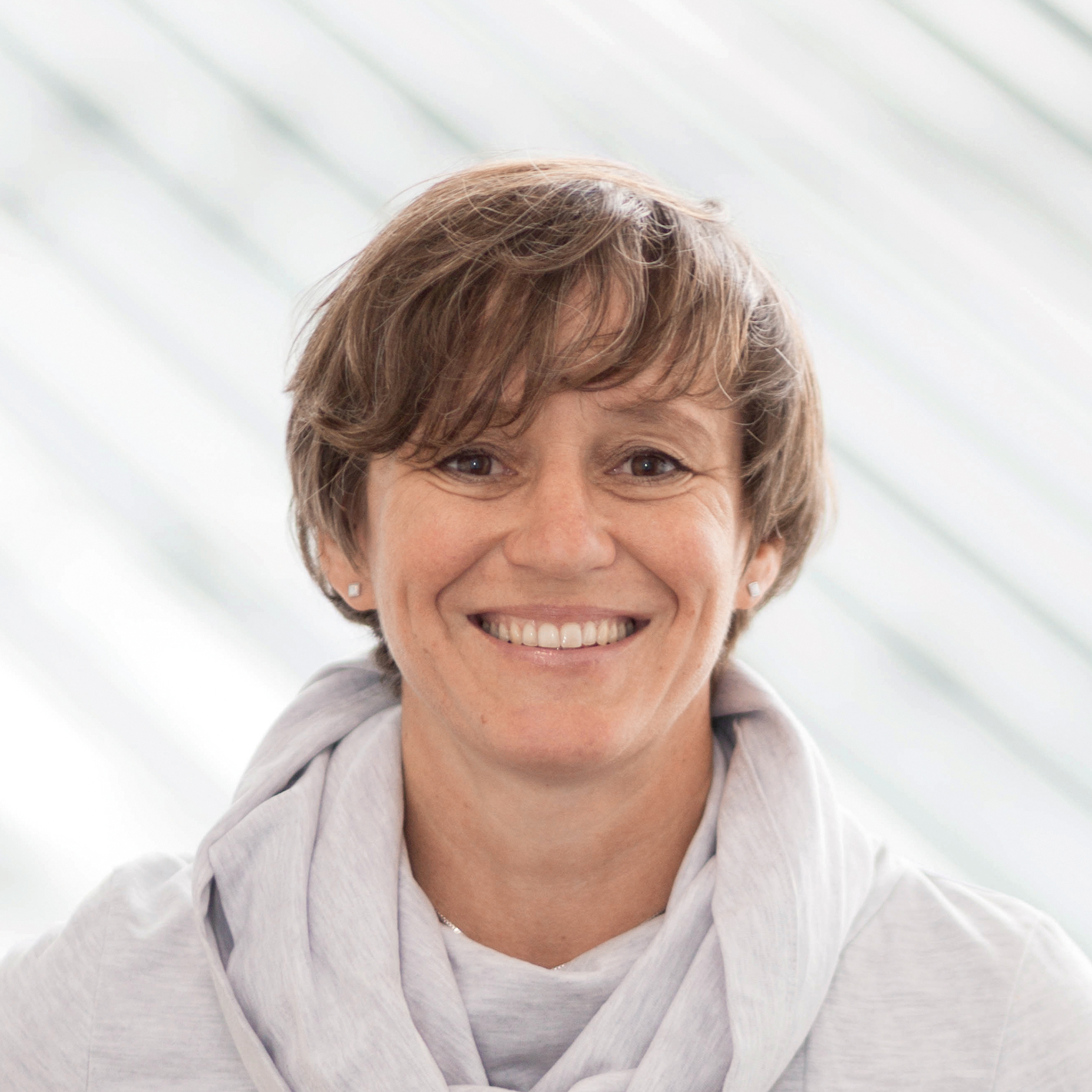 Ellen Dehnert, ÖAMTC-Expertin und Leiterin der Mobilitätsdienste. Portraitaufnahme, sie sieht in die Kamera. Sie trägt einen hellgrauen Pullover, sie lächelt. Ihre Haare und Augen sind braun. 