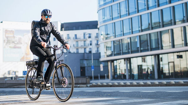 Männlicher Radfahrer mit Helm auf Straße