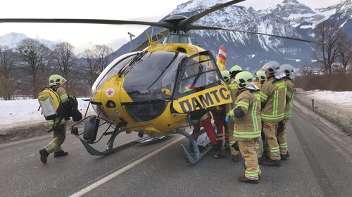 Ein ÖAMTC-Notarzthubschrauber, Feuerwehr und Polizei bei einem Unfall auf einer Straße. Am Straßenrand ist Schnee sichtbar.