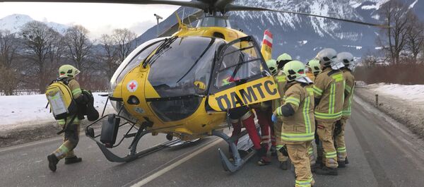Ein ÖAMTC-Notarzthubschrauber, Feuerwehr und Polizei bei einem Unfall auf einer Straße. Am Straßenrand ist Schnee sichtbar.