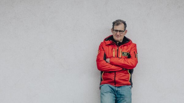 Helikopterpilot Robert Schornsteiner mit roter Jacke.