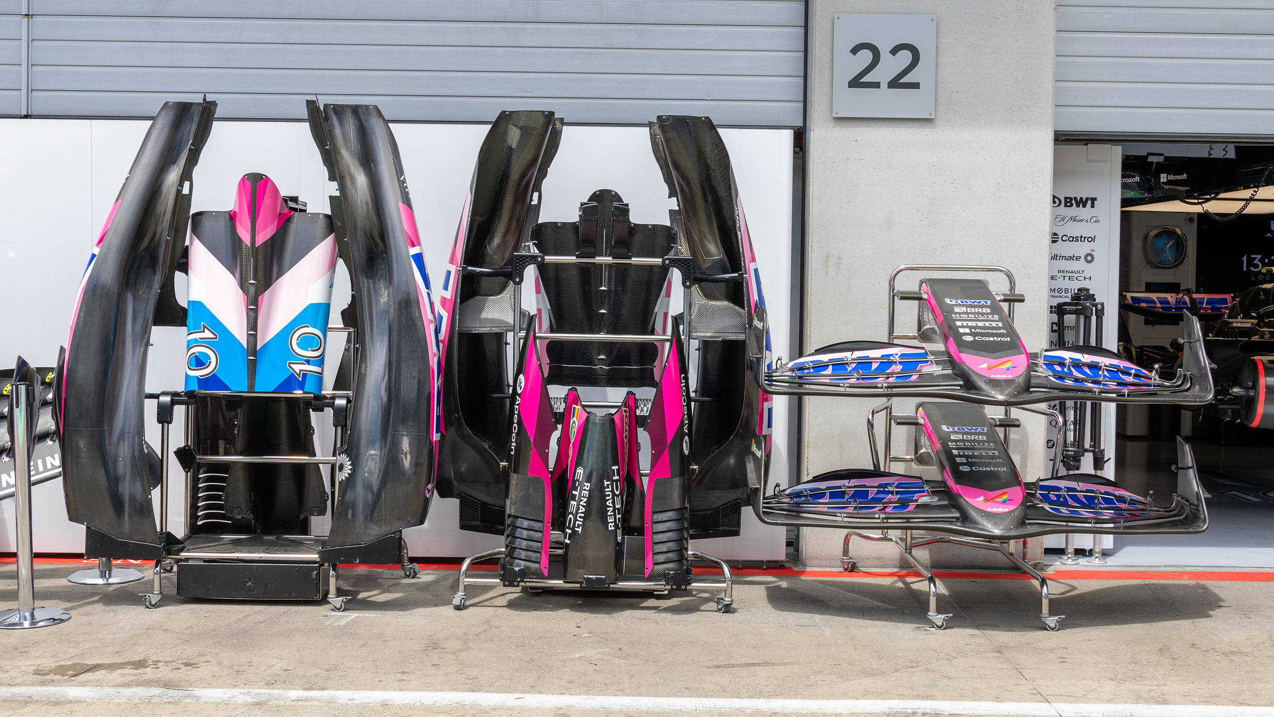 Abdeckungen eines Formel 1 Autos stehen vor einer Box.