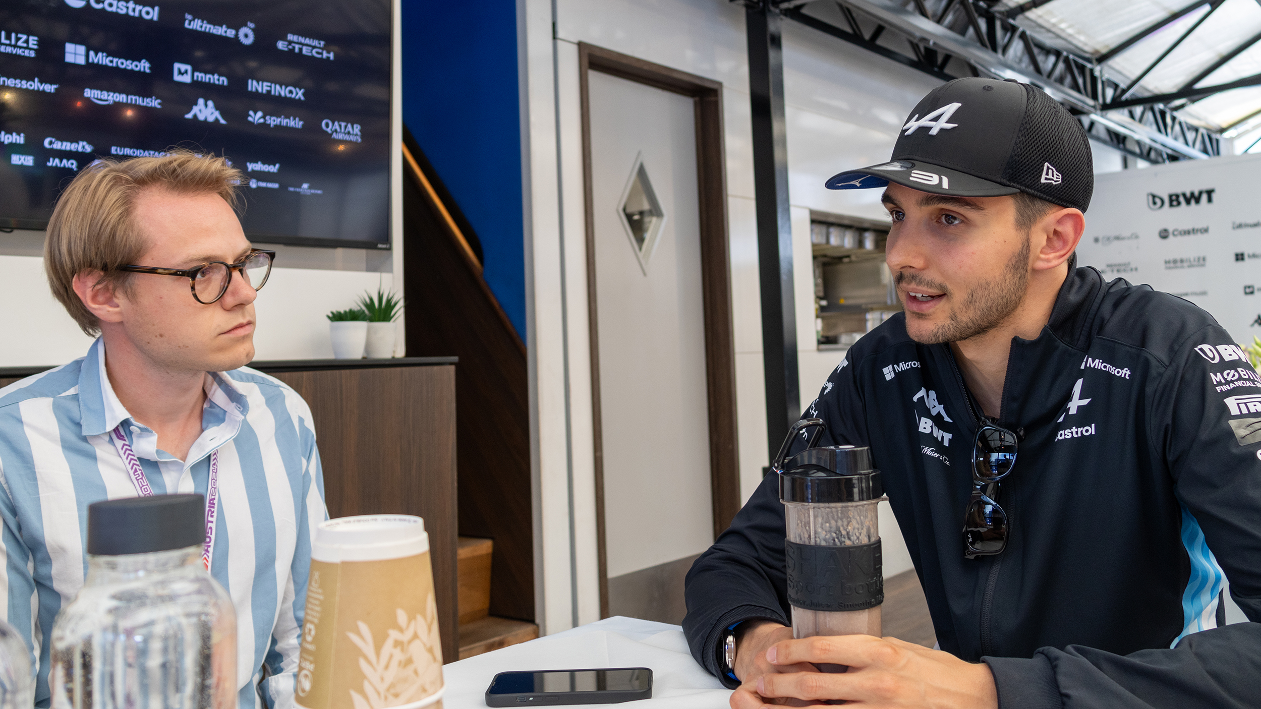 Der Formel-1-Fahrer Esteban Ocon unterhält sich mit einem Journalisten.