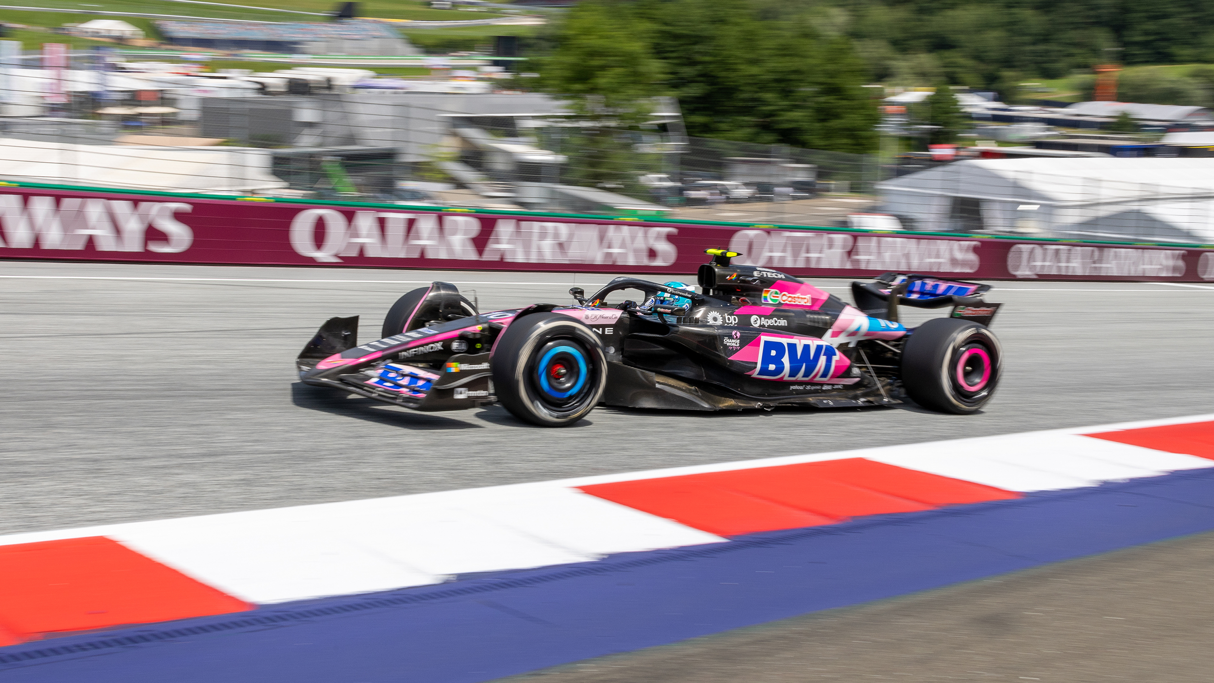 Ein schwarz-pinkes Formel 1 Auto fährt über den Red Bull Ring.