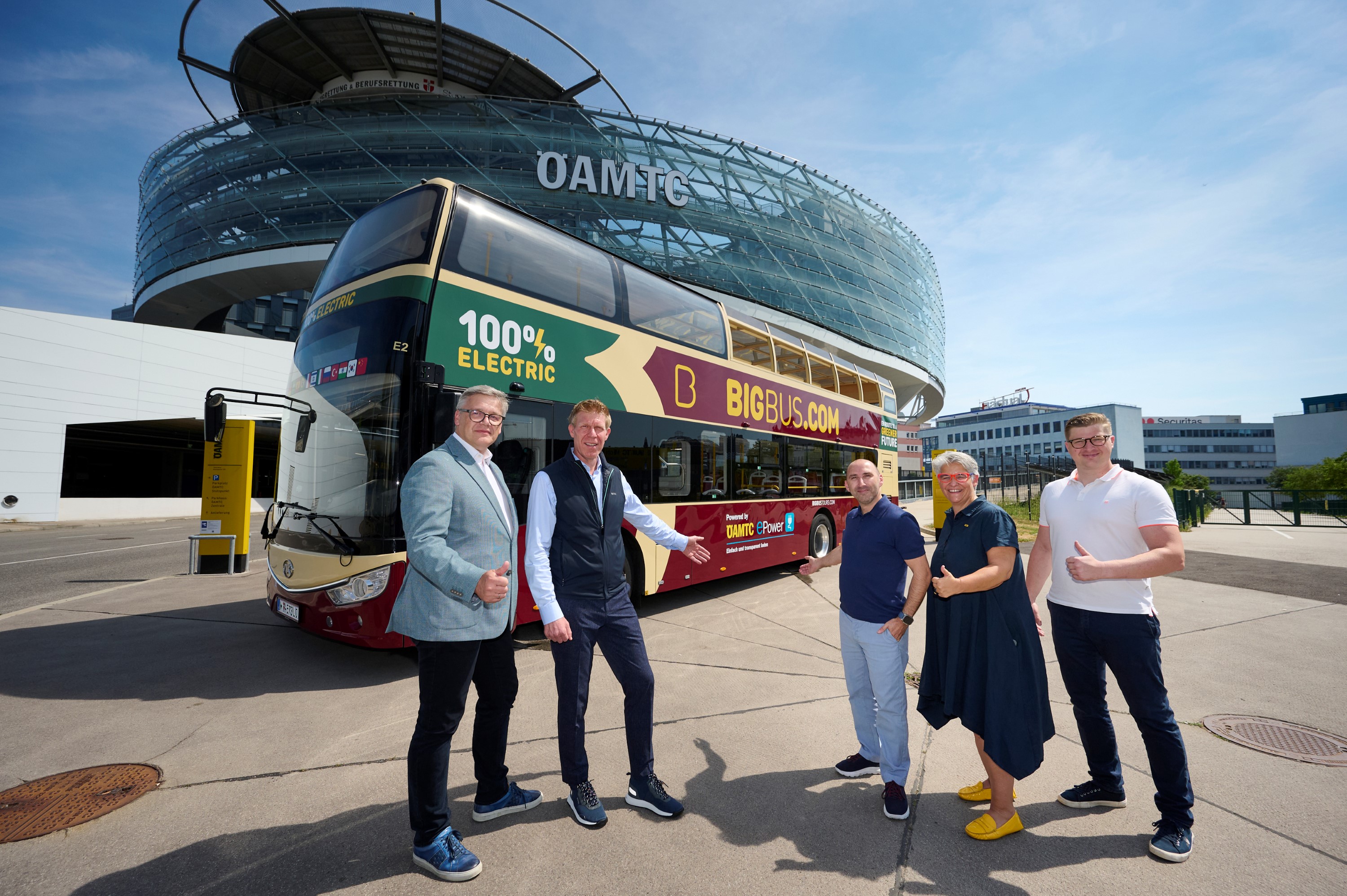 Ein großer Doppeldecker Reisebus steht vor dem ÖAMTC Mobilitätszentrum in Wien. Fünf Mitarbeiter vom ÖAMTC und Bis Bus stehen davor.