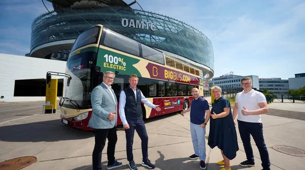 Ein großer Doppeldecker Reisebus steht vor dem ÖAMTC Mobilitätszentrum in Wien. Fünf Mitarbeiter vom ÖAMTC und Bis Bus stehen davor.