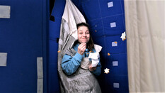 Marina Blanke isst Astronautennahrung, während sie in einem Schlafsack für Astronauten hängt.