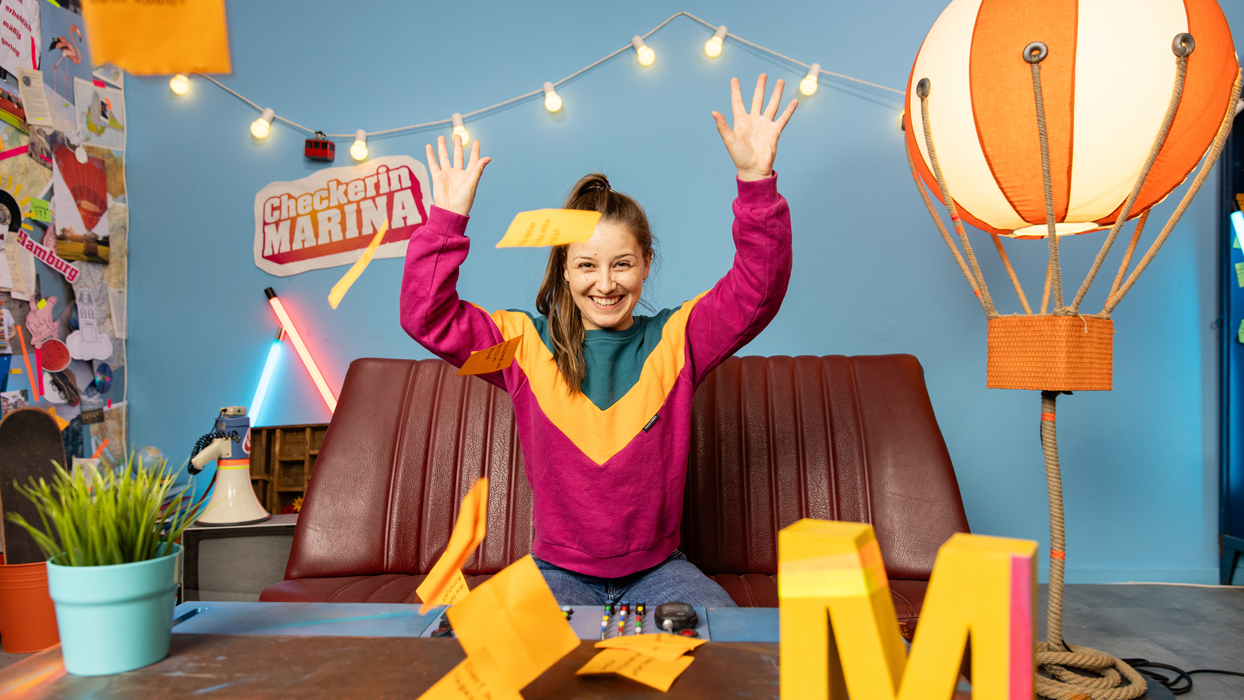 Marina Blanke sitzt am Sofa im Checker-Studio.