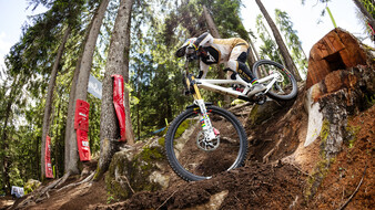 Mountainbikerin Vali Höll auf einer Downhill Strecke im Wald.