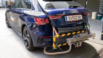 Wie's aussieht, wenn's fertig (angeschlossen) ist: Ein Portable Emission Measurement System, kurz PEMS. Ein am Heck eines blauen Autos montiertes mobiles Abgasmessgerät.
