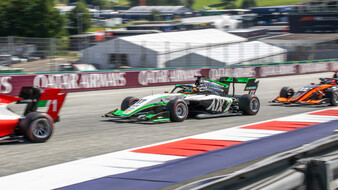 Ein grün-weißes Formel 3-Rennauto fährt über den Red Bull Ring, davor befindet sich ein rot-weißes, dahinter ein schwarz-oranges Formel-3-Fahrzeug.