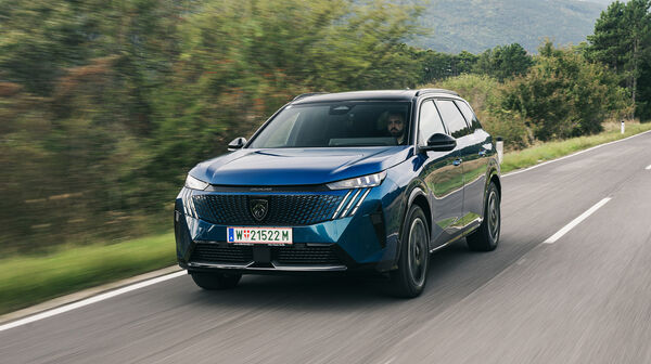 Ein blaues SUV fährt auf einer Landstraße