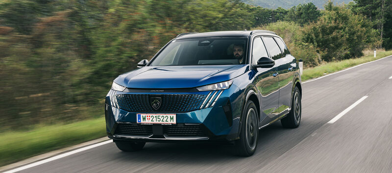Ein blaues SUV fährt auf einer Landstraße