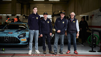 Vier technische Kommissare stehen vor einer Box am Red Bull Ring, im Hintergrund ist ein Rennauto zu sehen.