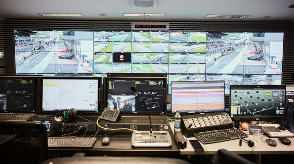 Der Race-Controll-Room des Red Bull Rings mit einer Wand voller Bildschirme, im Vordergrund befinden sich viele Laptops und Tastaturen.