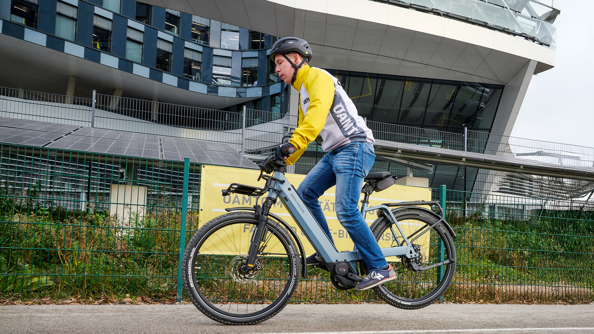 Ein Mann in gelber Jacke bei einer Vollbremsung am Fahrrad