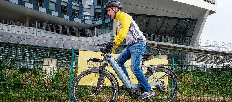 Ein Mann in gelber Jacke bei einer Vollbremsung am Fahrrad