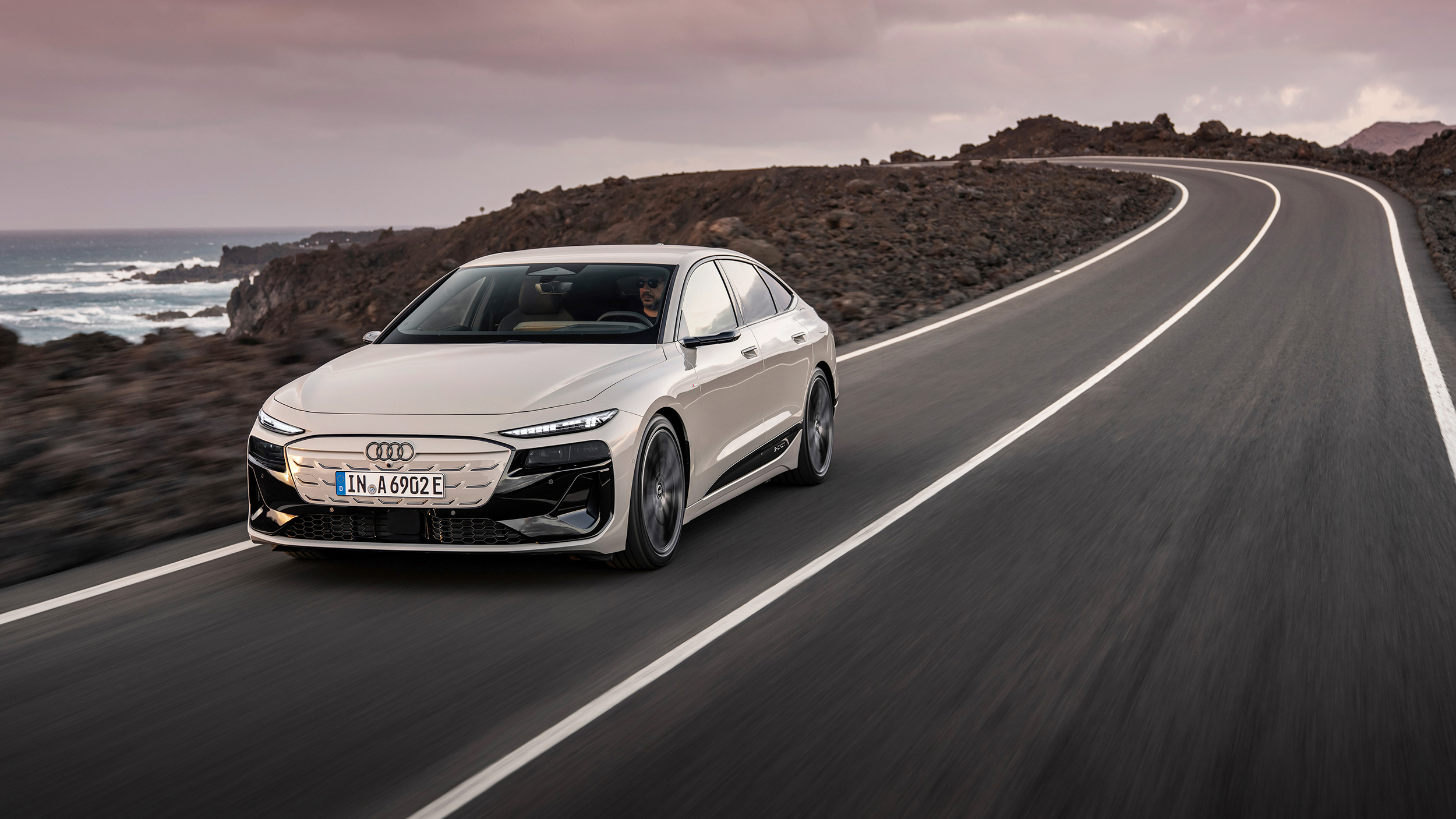 Ein weißer Audi fährt am Meer entlang