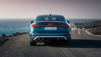 Das Heck eines blauen Audi am Meeresufer