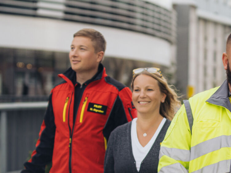 Header Karriere 2025 Vielseitig.jpg Sechs ÖAMTC Mitarbeiter und Mitarbeiterinnen gehen gemeinsam vor dem Mobilitätszentrum auf die Kamera zu.