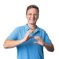 Kollege mit kurzen blonden Haaren zeigt eine Geste in Gebärdensprache. Er trägt ein hellblaues Poloshirt.