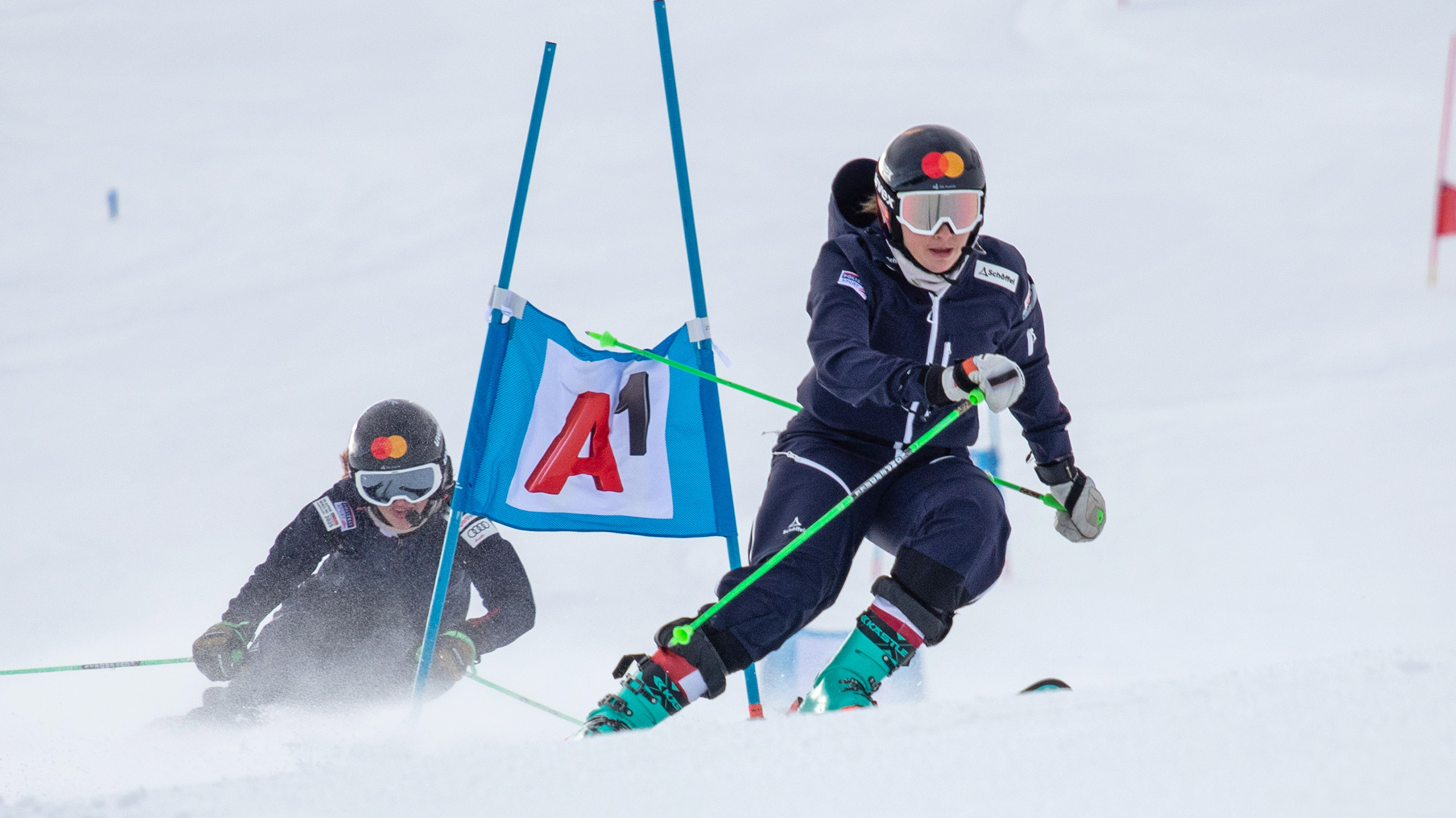 Zwei Paraskifahrerinnen beim Riesentorlauf auf der Piste.
