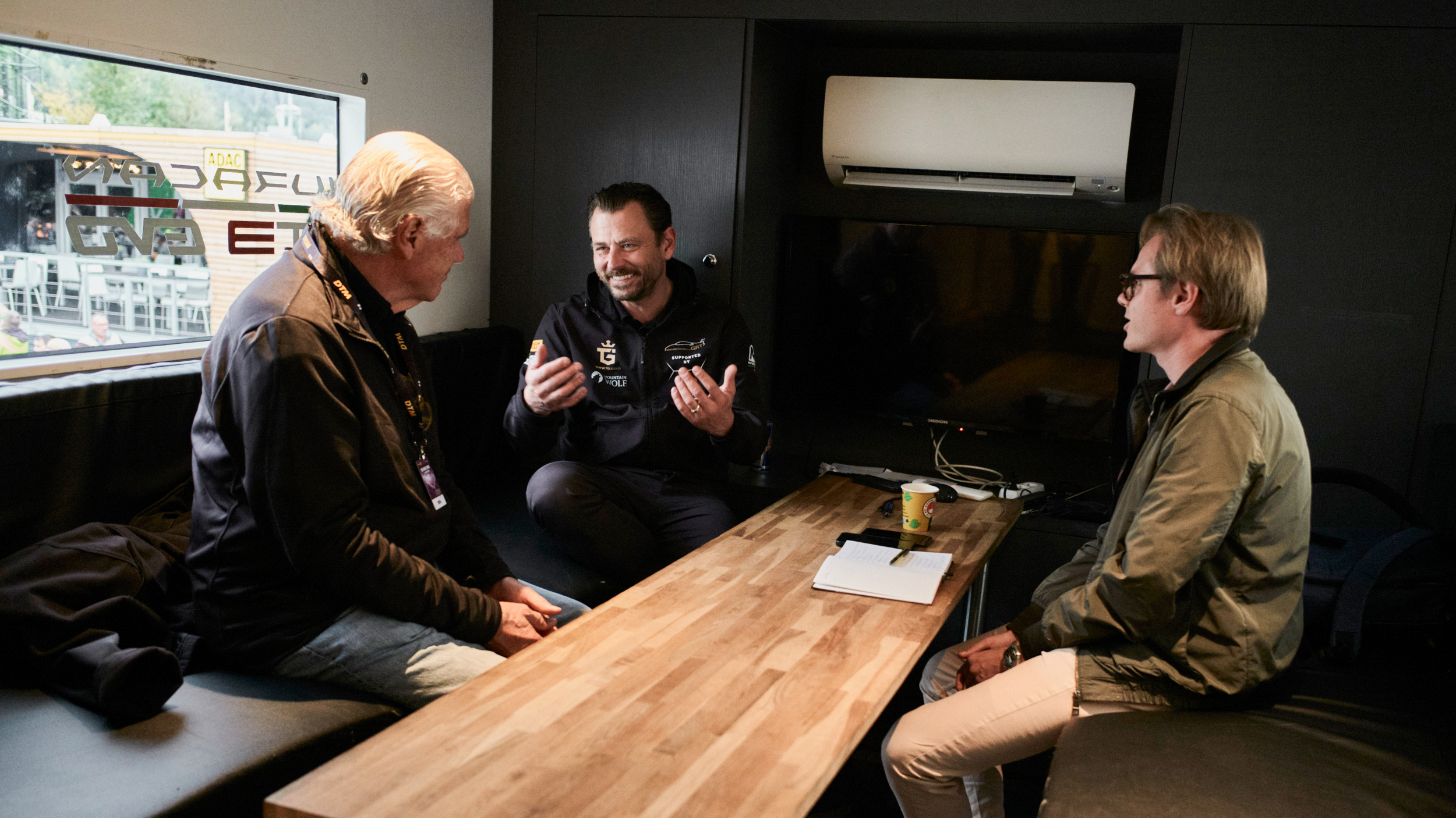 Gottfried Grasser, Teamchef eines GT3-Rennteams, wird von einem Journalisten und Dr. Harald Hertz, Vizepräsident des ÖAMTC, interviewt.