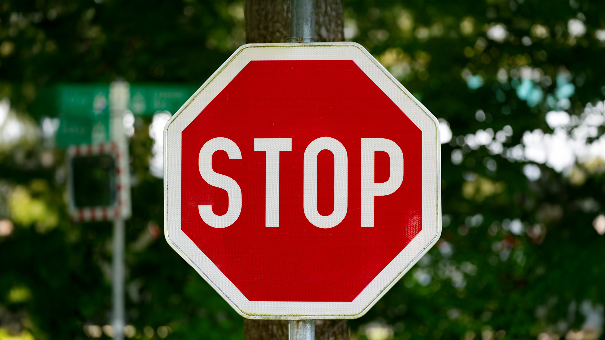 Ein Stoppschild, im Hintergrund eine Hecke