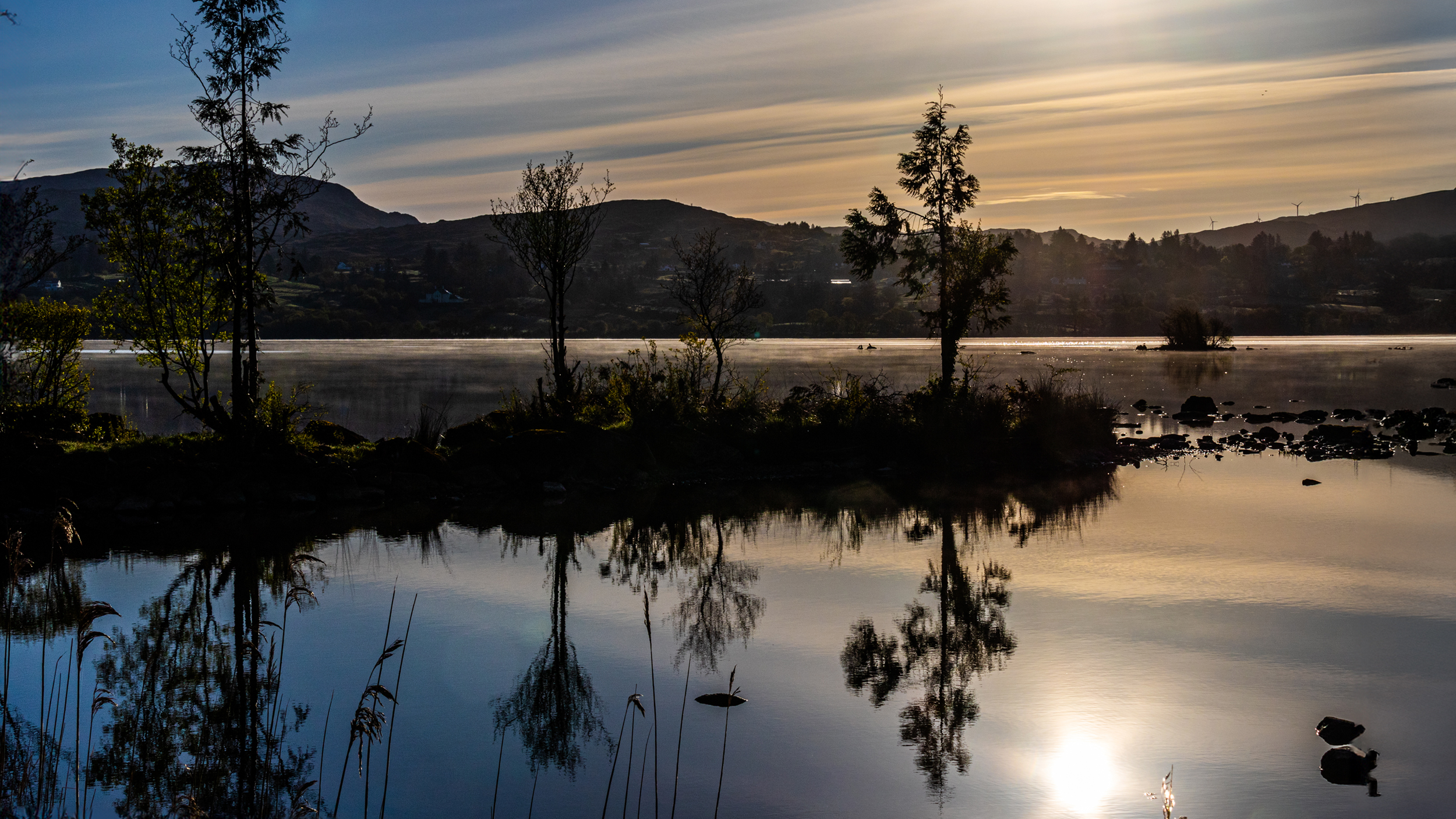 Sonnenaufgang an einem See mit Morgennebel.