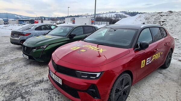 Drei Elektroautos stehen in Winterlandschaft nebeneinander