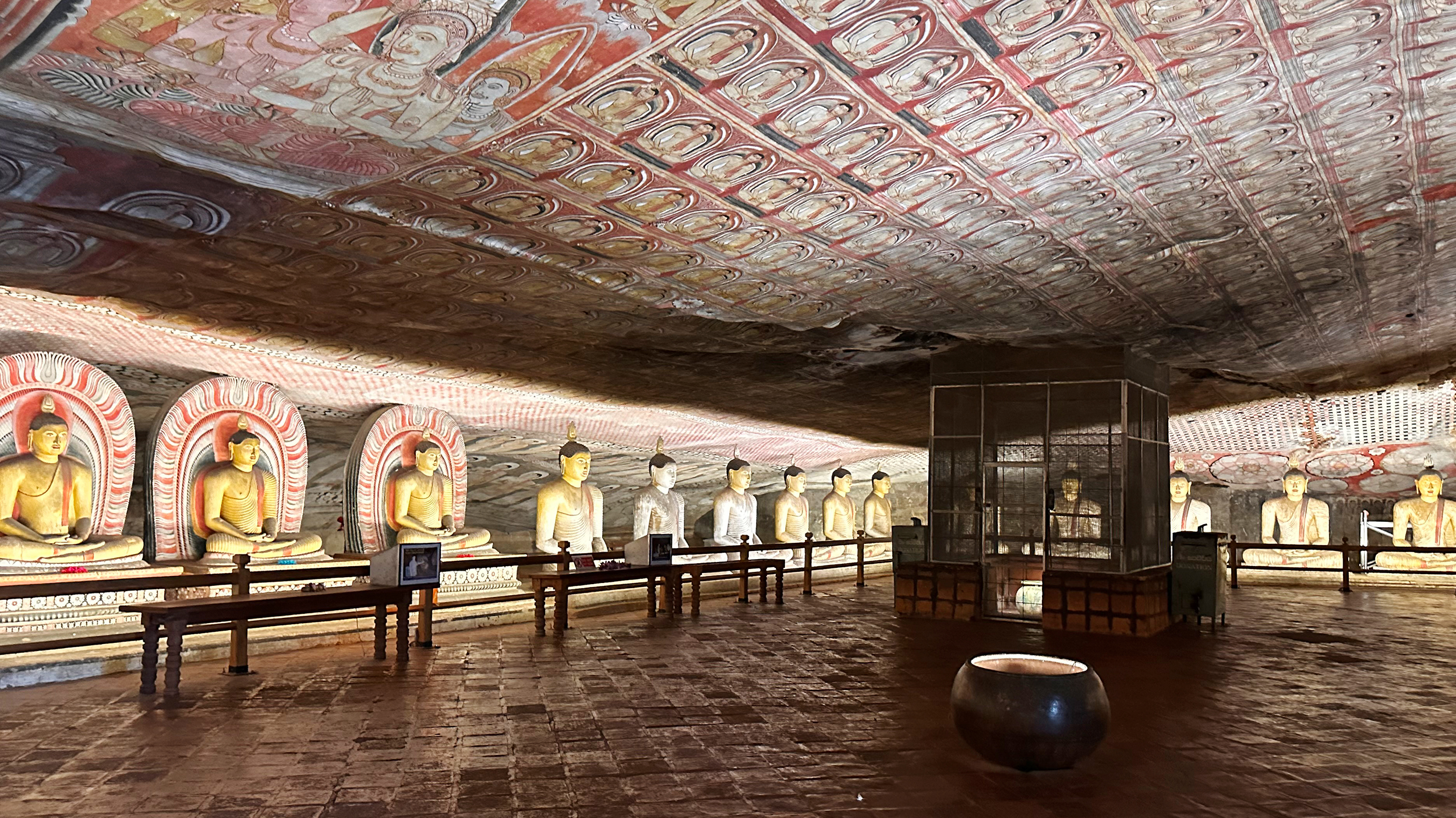 Dambulla-Höhlentempel von innen. Es sind viele Buddha-Statuen zu sehen.