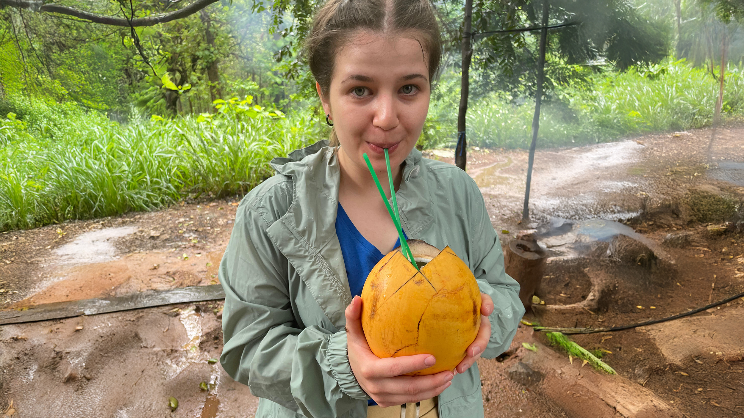 Redakteurin Verena Schauer trinkt mit einem Strohhalm aus einer orangenen Kokosnuss.