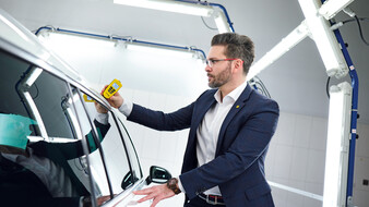 Michael Planer verwendet ein Lackschichtdichten-Messgerät an einem Auto