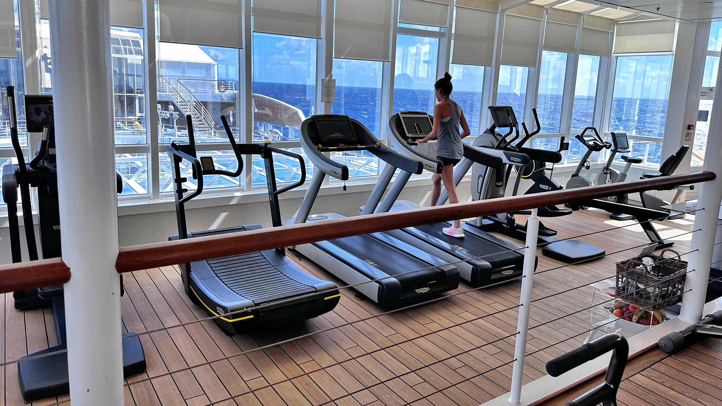 Man sieht den Fitness-Raum der MS Europa mit Blick auf das Wasser.
