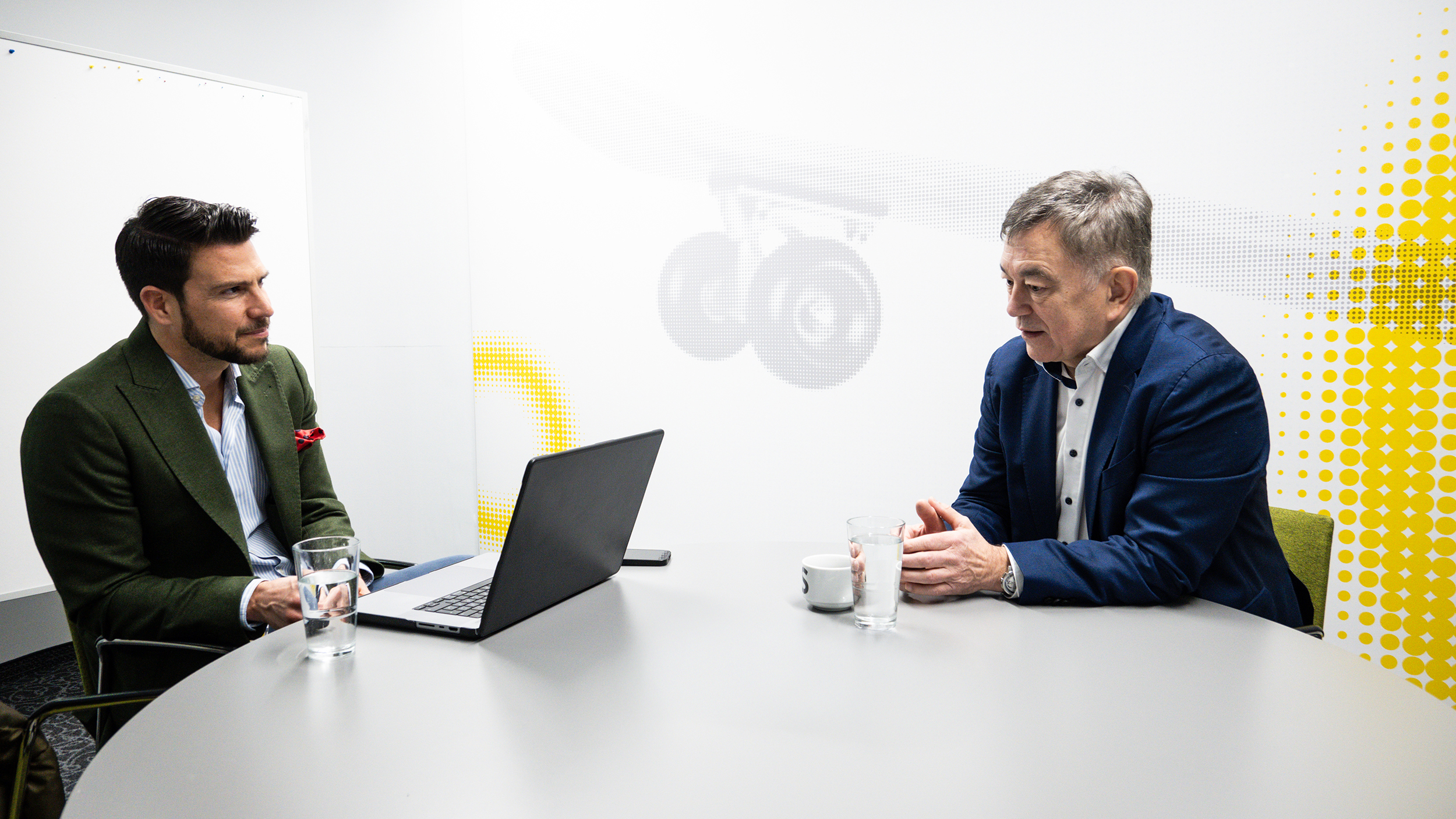 Brigadier Walter J. Unger und auto touring Chefredakteur Stephan Höckner sitzen plaudernd in einem hellen Besprechungsraum.