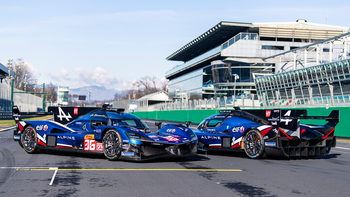 Zwei blaue Langstrecken-Rennwagen der Marke Alpine stehen auf der Start-Ziel-Gerade einer Rennstrecke.
