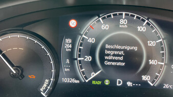 Tachometer eines Mazda MX-30, auf dem ein orangenes Schildkröten-Symbol sowie die Information, das die Beschleunigung begrenzt ist, angezeigt wird.