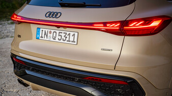 Das Heck eines beigen Audi Q5 mit durchgehendem Leuchtenband.