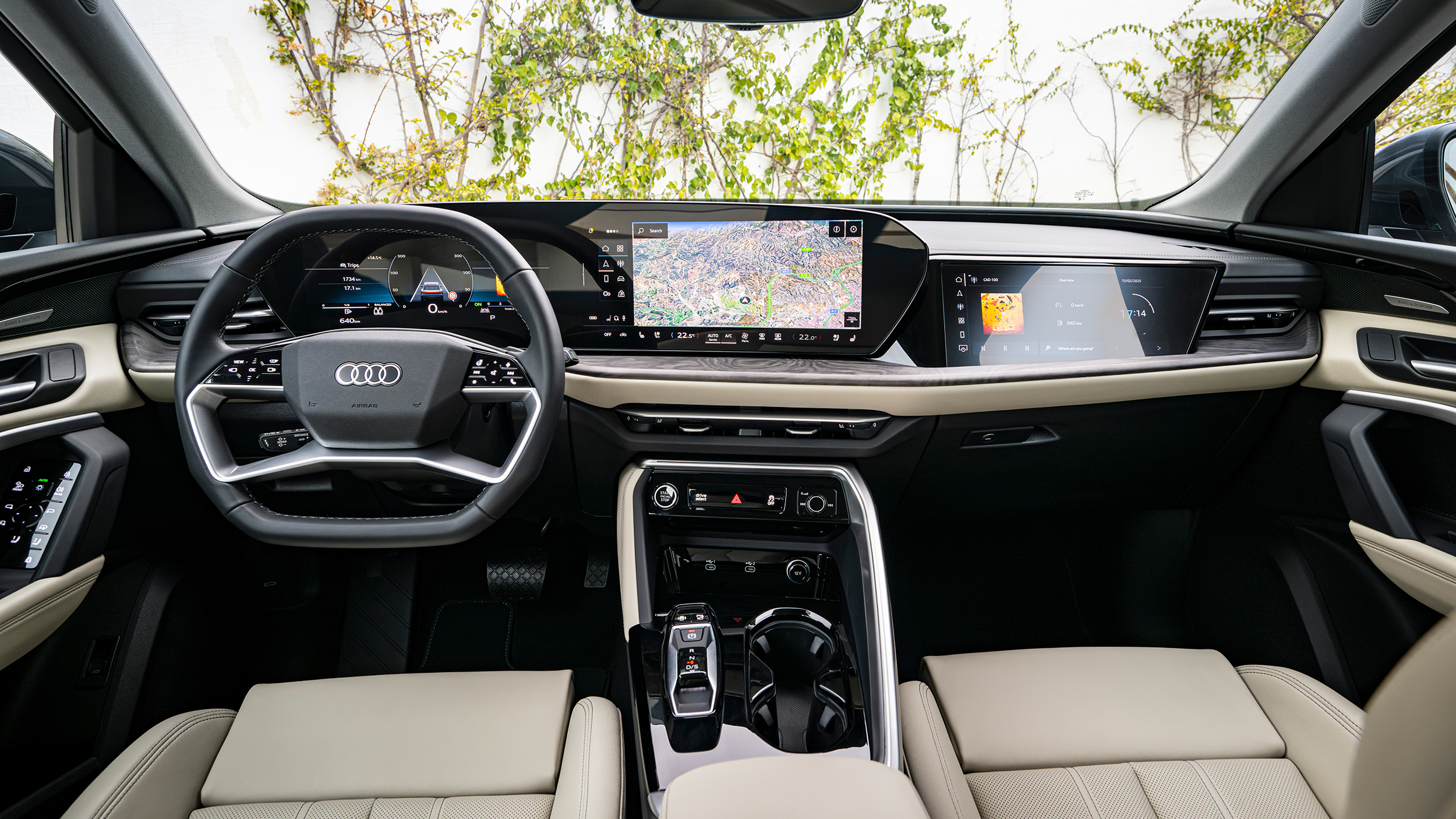 Innenraum eines Audi Q5 mit beigen Vordersitzen, Panoramadisplay und Beifahrerdisplay.