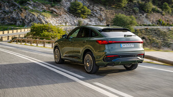 Heck eines auf der Landstraße fahrenden, grünen Audi Q5 Sportback.