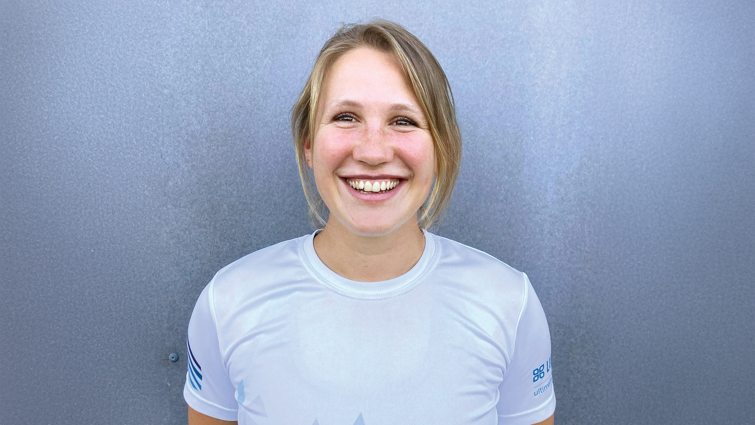 Eine blonde Frau lacht in die Kamera